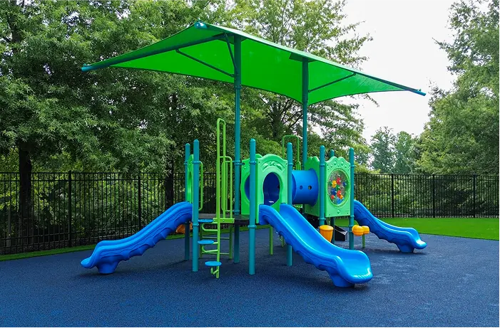 Childcare playground with slides under shade canopy, installed by Pro Playgrounds