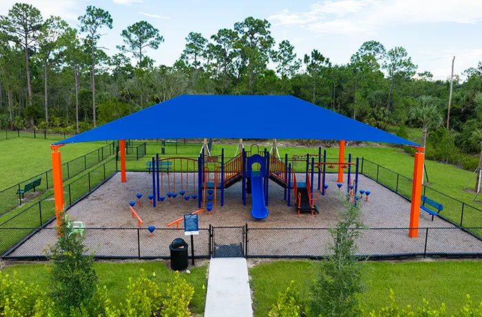 Large shaded playground with climbing and slides, installed by Pro Playgrounds park playground