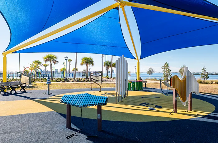 Outdoor musical instruments under shade canopy in park, installed by Pro Playgrounds