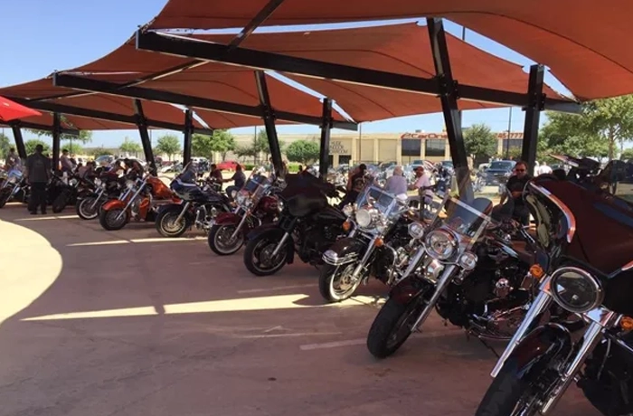 Shade structure installation for a commercial motorcycle parking area.