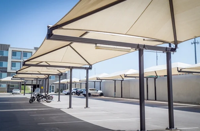 Shade structure installation with hip-style fabric parking canopies.