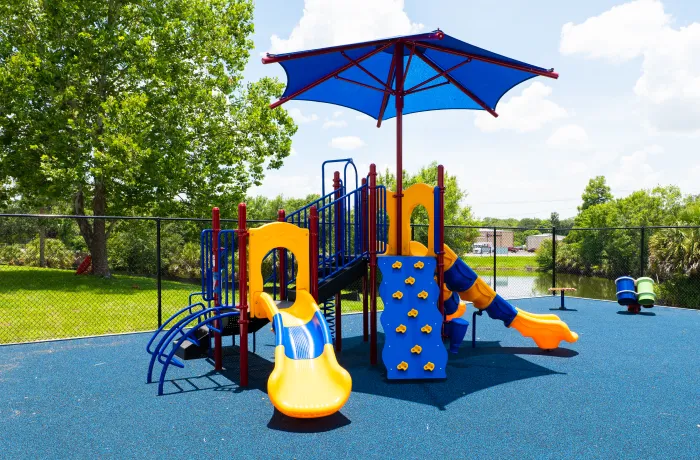 Completed playground by Pro Playgrounds with play structure and shade canopy on rubber surface