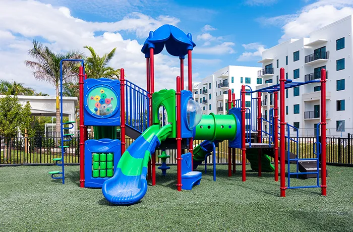 Grenn rubber mulch surfacing around colorful playground structure, installed by Pro Playgrounds