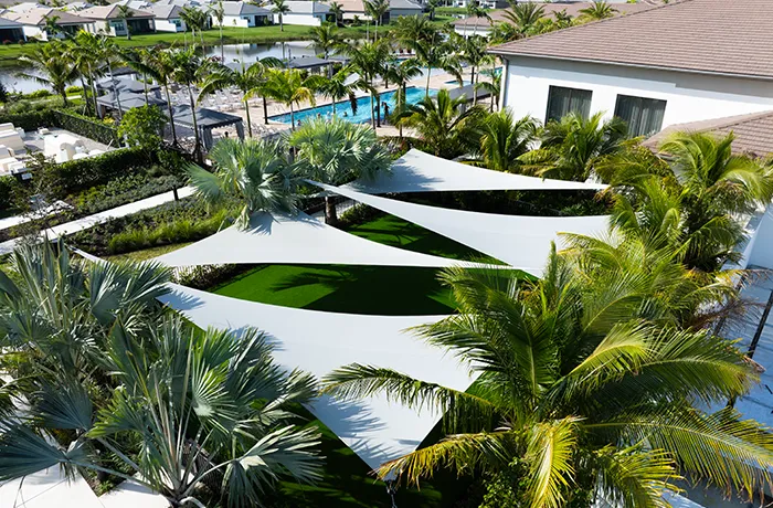 Completed shade structure installation by Pro Playgrounds with white sail shades over landscaped courtyard