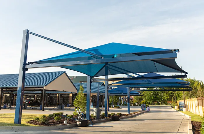 Blue cantilever shade structures over commercial drive-thru lane with steel posts