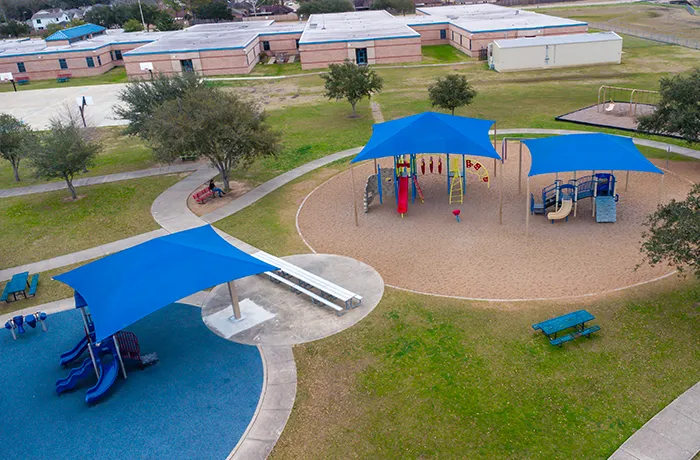 Completed shade structure installation by Pro Playgrounds with blue shades over school playground