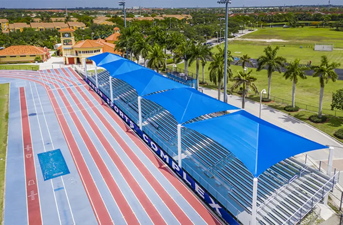 Completed shade structure installation by Pro Playgrounds with blue rectangle shade canopies over bleachers