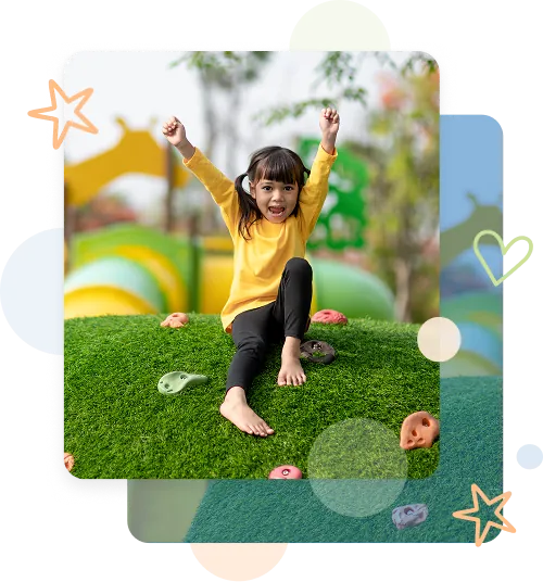 Artificial-Turf-for-Playgrounds-and-Athletic-Fields-2 Child sitting on artificial turf play mound with climbing holds on green synthetic grass surface