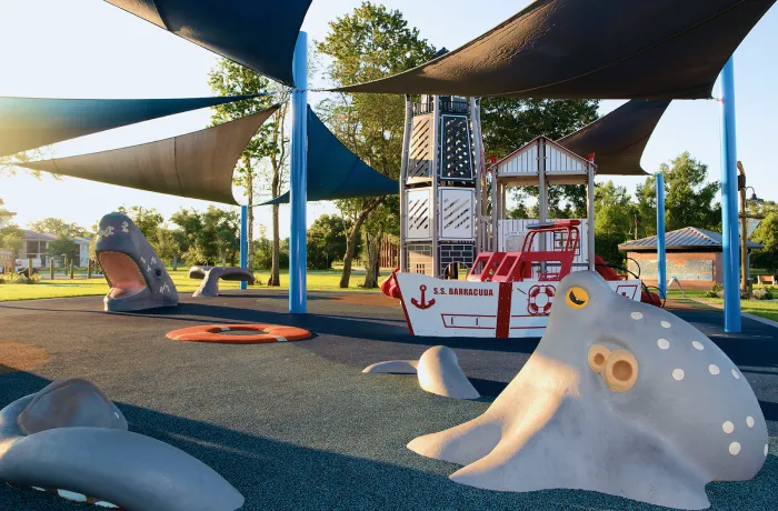Marine-themed play area with ship structure and shade sails, completed playground by Pro Playgrounds.