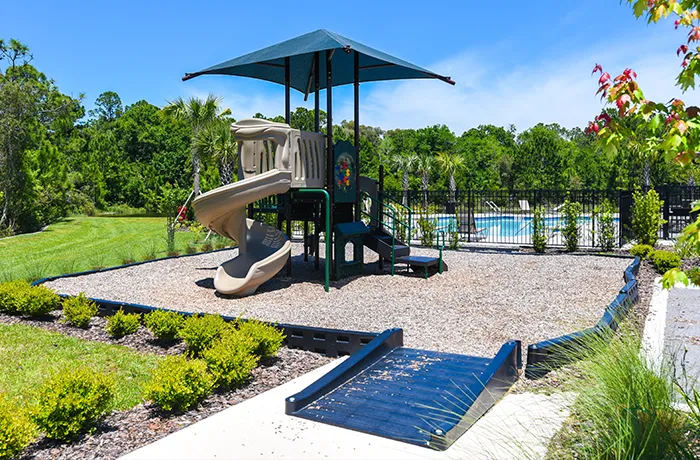 Small play structure with slide and ramp, completed playground by Pro Playgrounds in residential area.