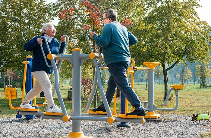 Seniors using outdoor fitness equipment in a public park