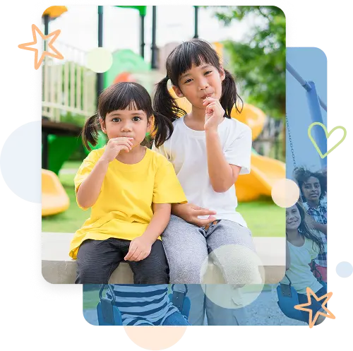Two children sitting in front of park playground equipment with play structure in background